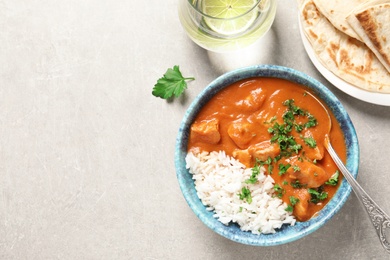 Delicious butter chicken with rice served on table, flat lay. Space for text