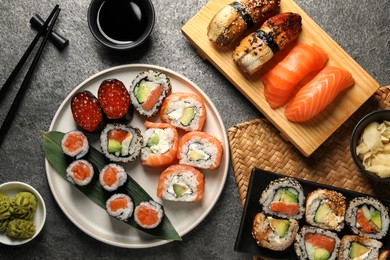 Flat lay composition with delicious sushi rolls on dark grey table