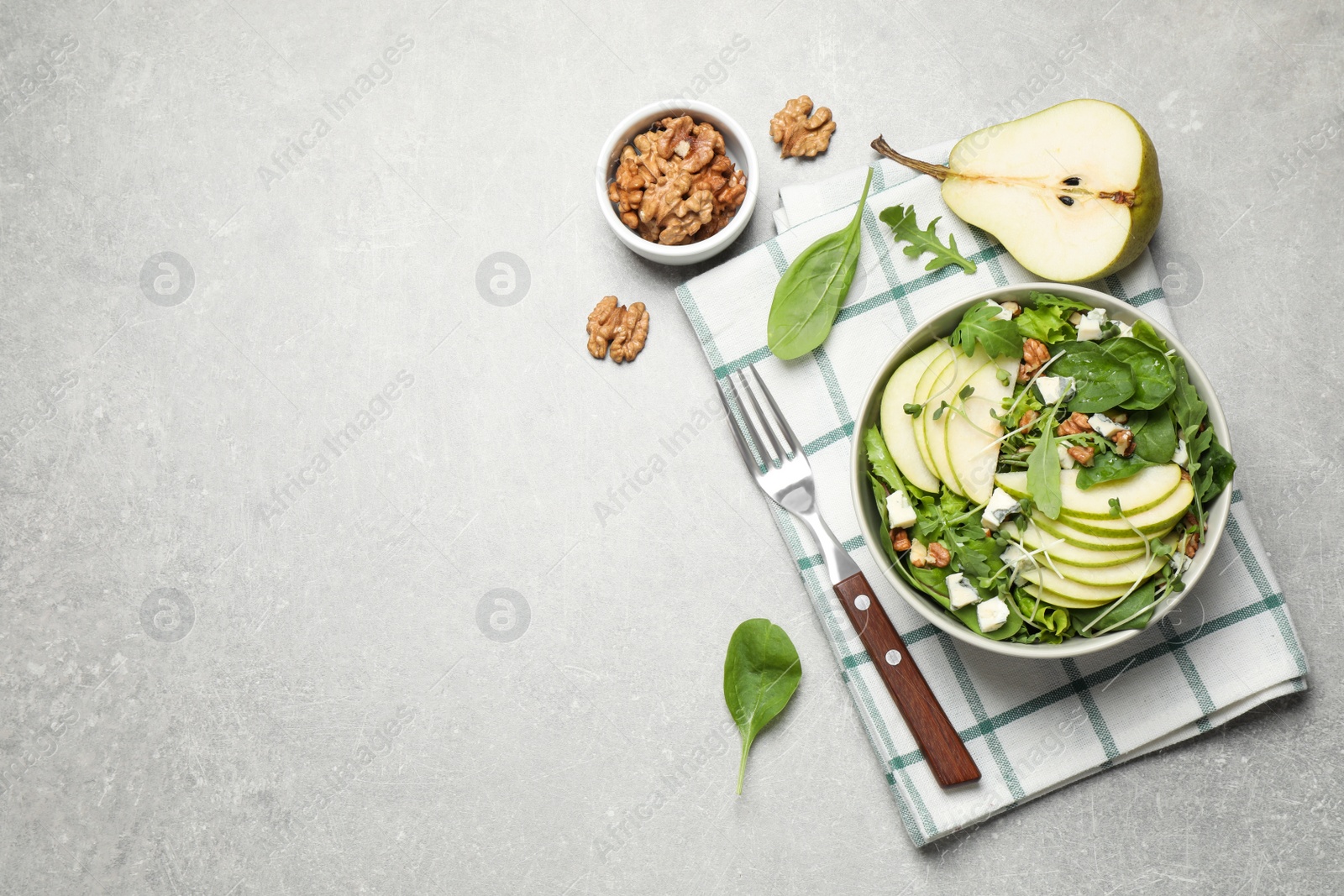 Photo of Tasty salad with pear slices served on light grey table, flat lay. Space for text