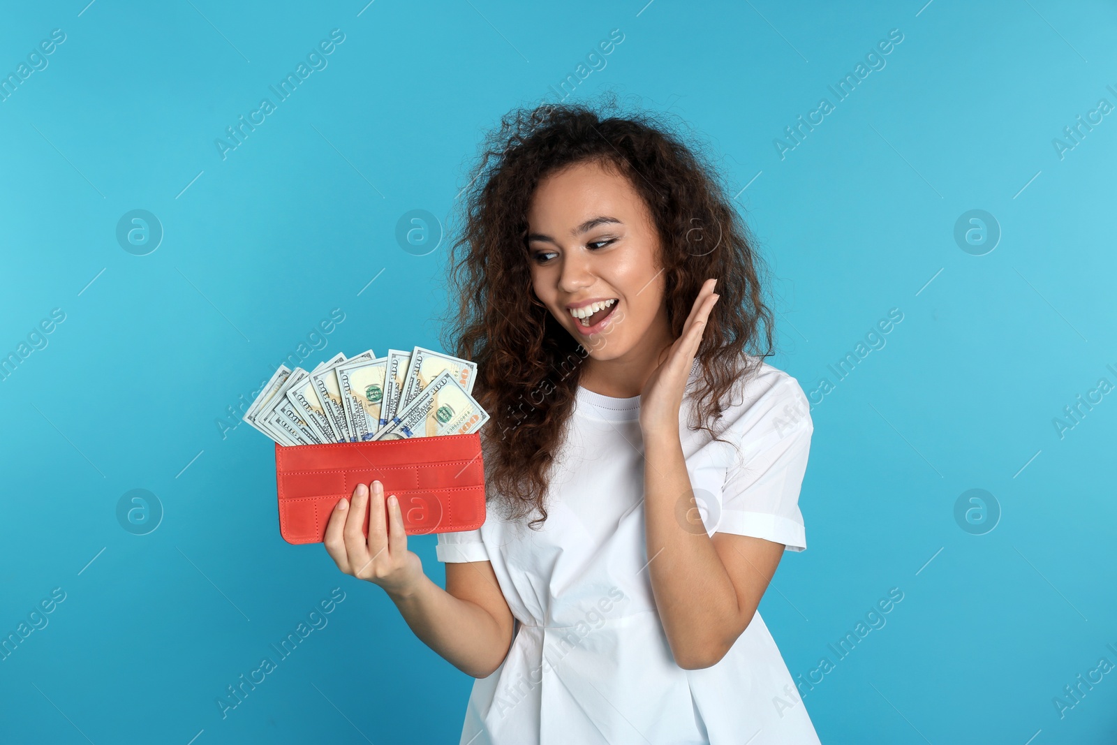 Photo of African-American woman with money in wallet on color background