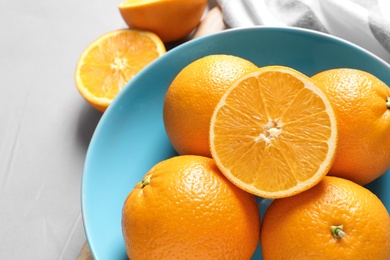 Plate with fresh ripe oranges on table, above view