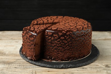 Photo of Delicious chocolate truffle cake on wooden table