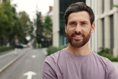 Portrait of handsome bearded man on street, space for text