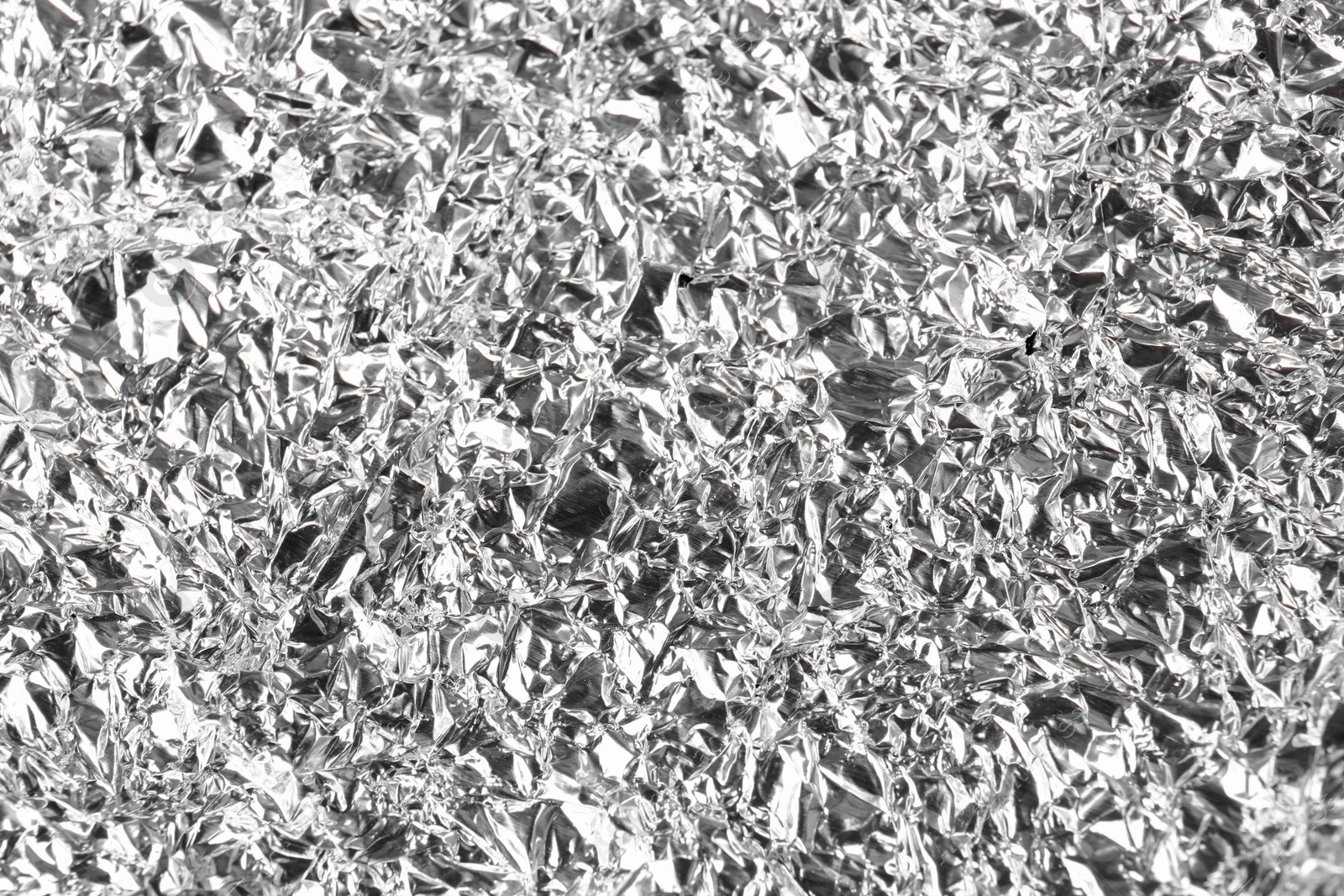 Photo of Crumpled silver foil as background, closeup view