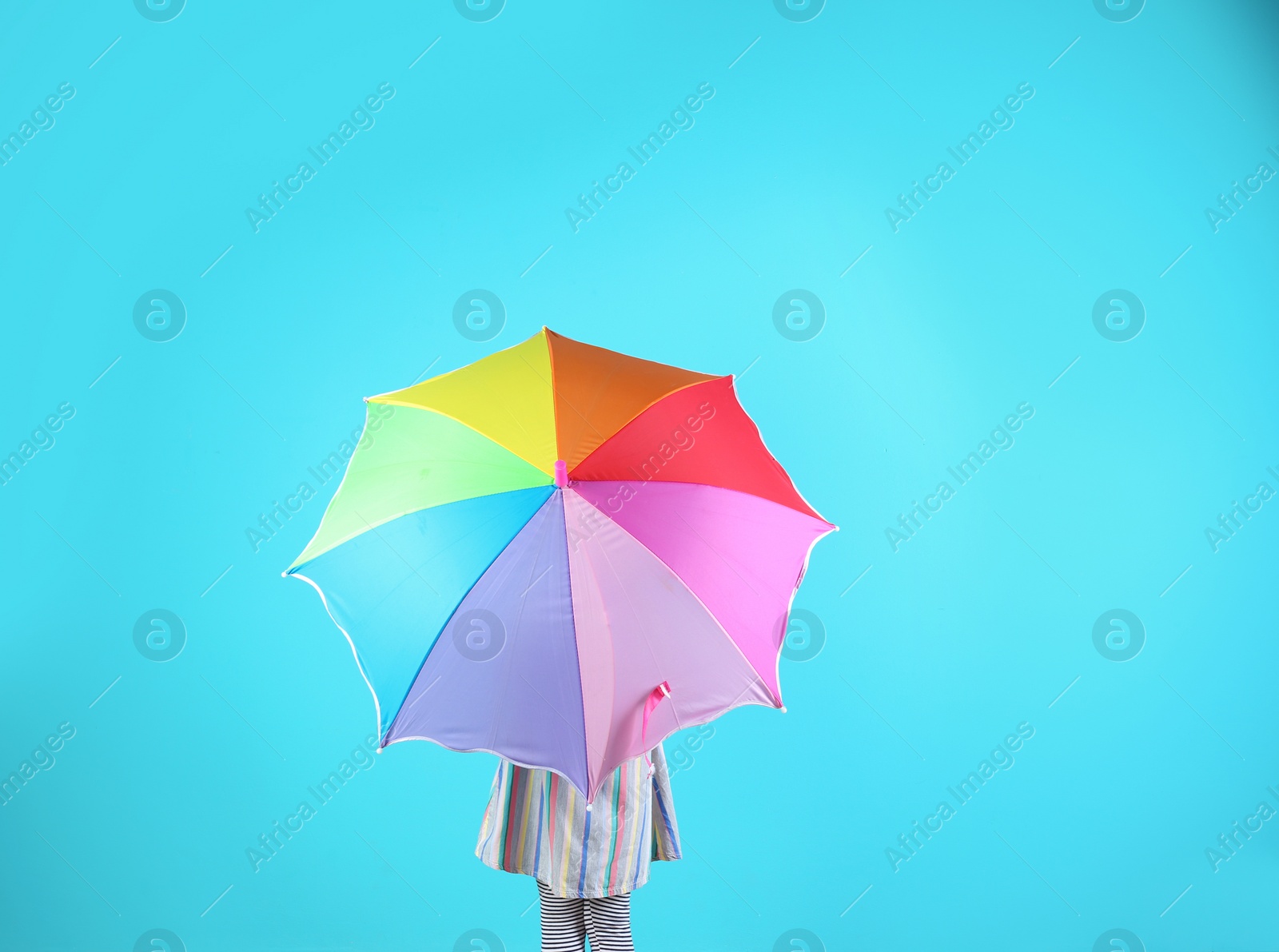 Photo of Little girl with rainbow umbrella on color background