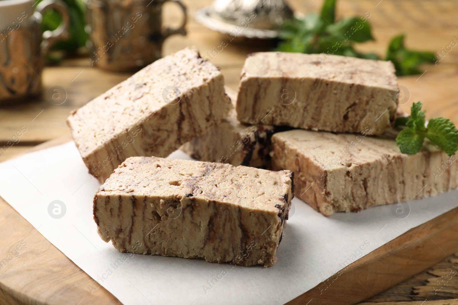 Photo of Tasty chocolate halva with mint on table, closeup