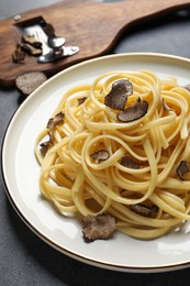 Photo of Tasty fettuccine with truffle on grey table, closeup