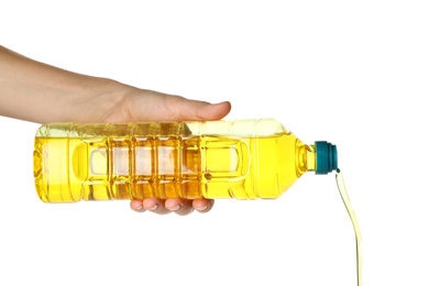 Woman pouring cooking oil from bottle on white background, closeup