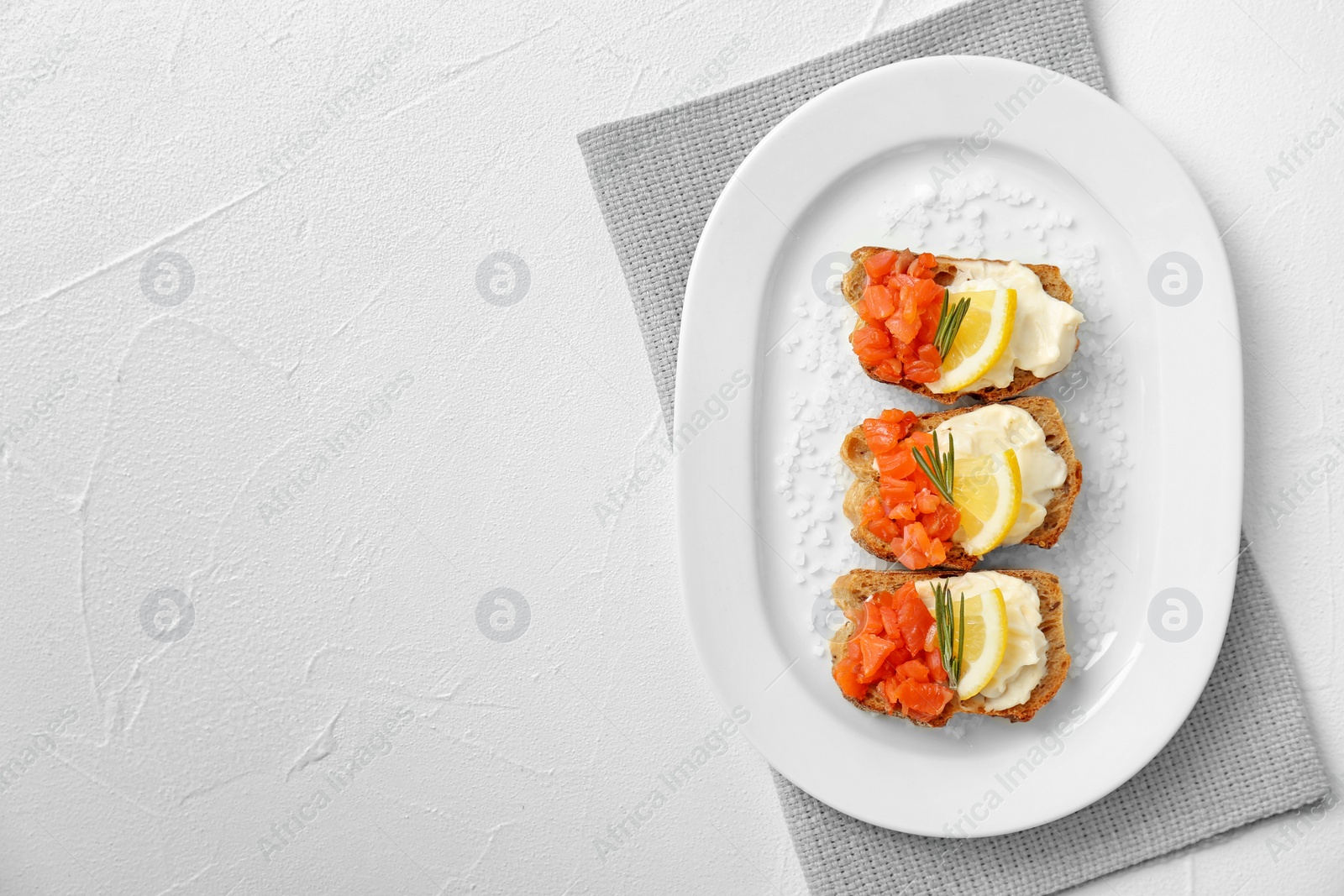 Photo of Plate of tasty sandwiches with fresh sliced salmon fillet on table, top view