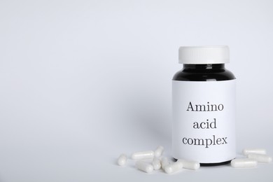 Photo of Amino acid complex and pills on white background. Space for text