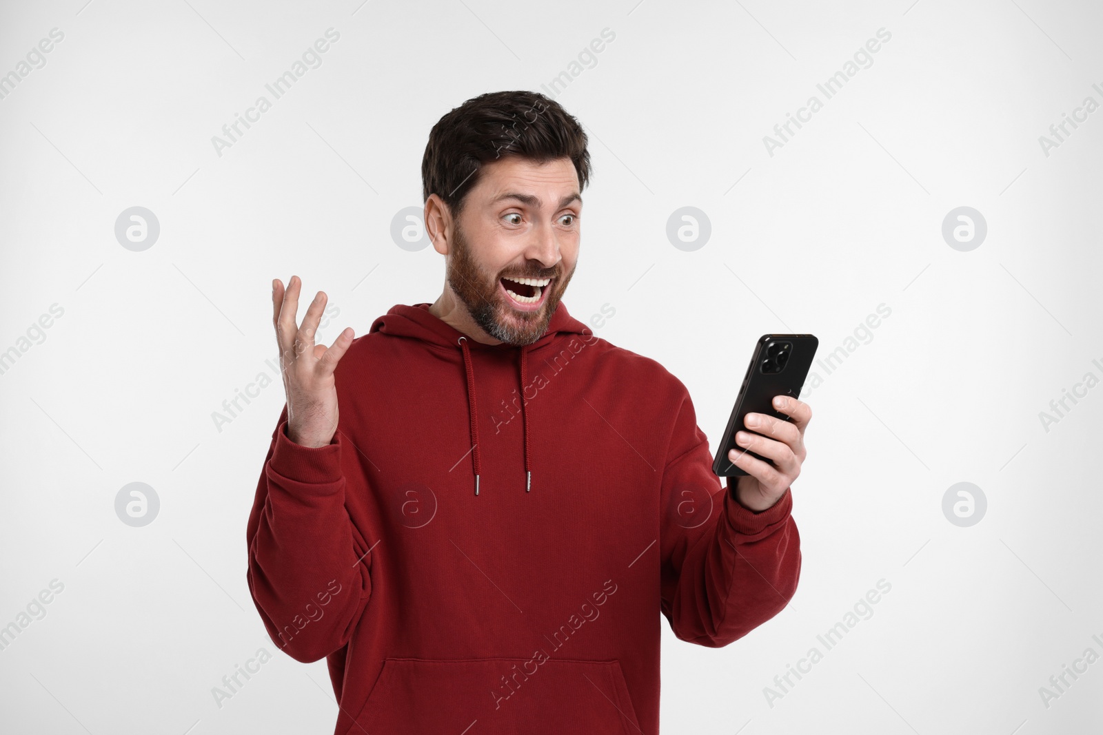 Photo of Emotional man with smartphone on white background