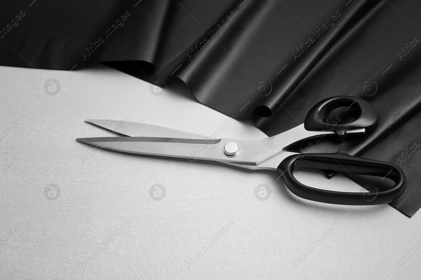 Photo of Scissors and fabric on grey background. Tailoring items