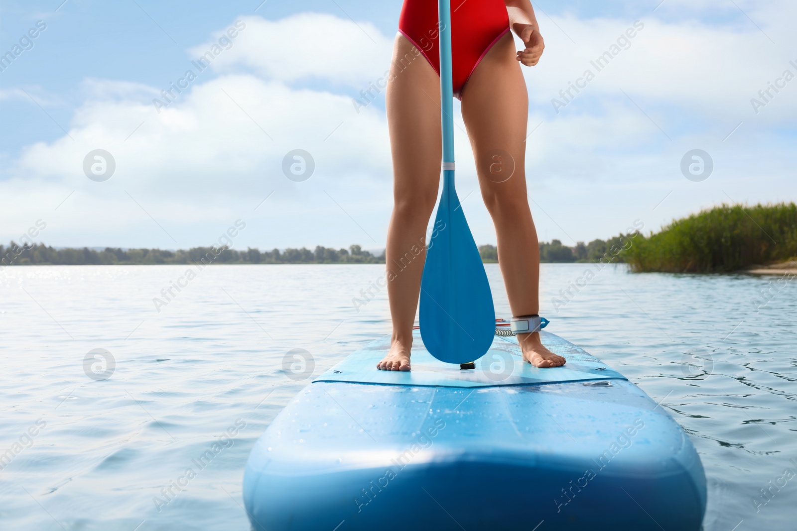 Photo of Woman paddle boarding on SUP board in sea, closeup
