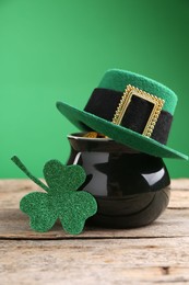 St. Patrick's day. Pot of gold with leprechaun hat and decorative clover leaf on wooden table