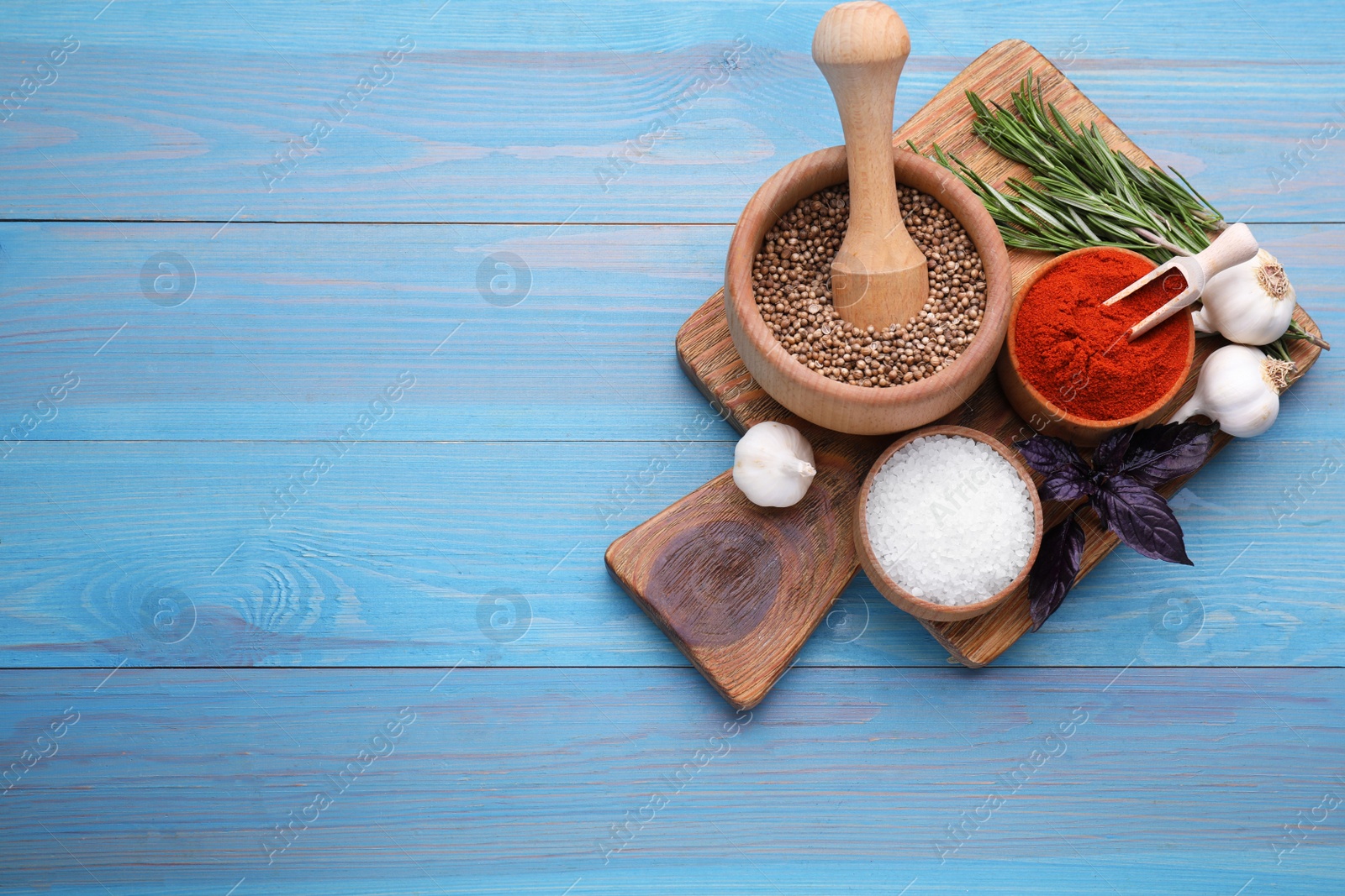 Photo of Flat lay composition with mortar and different spices on light blue wooden table, space for text