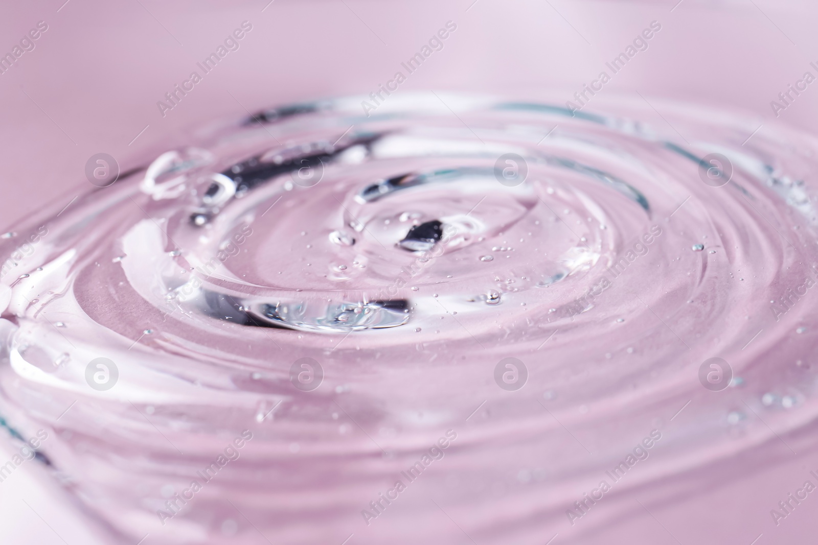 Photo of Sample of transparent shower gel on violet background, closeup