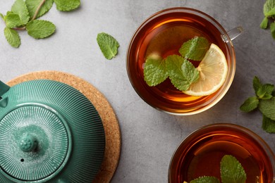 Aromatic herbal tea with mint and lemon on grey table, flat lay