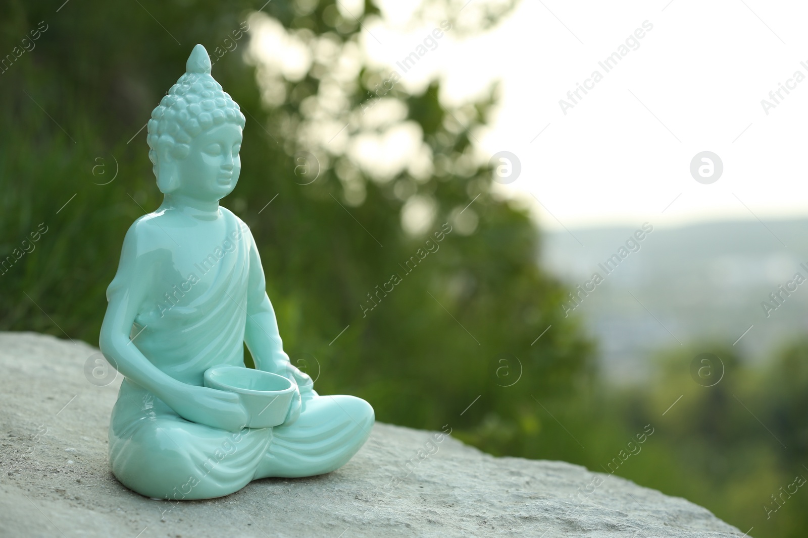 Photo of Decorative Buddha statue on stone outdoors, space for text