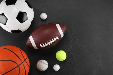 Photo of Many different sports balls on dark gray background, flat lay. Space for text