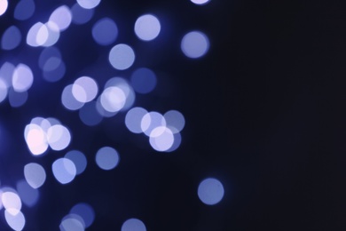 Photo of Blurred view of beautiful lights on dark background, space for text