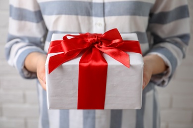 Photo of Woman holding beautiful gift box, closeup