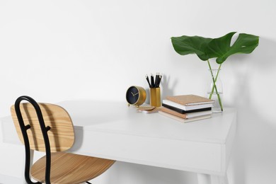 Photo of Comfortable workplace with white desk near wall
