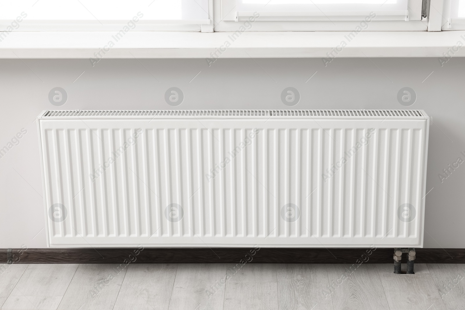 Photo of Modern radiator in room. Central heating system