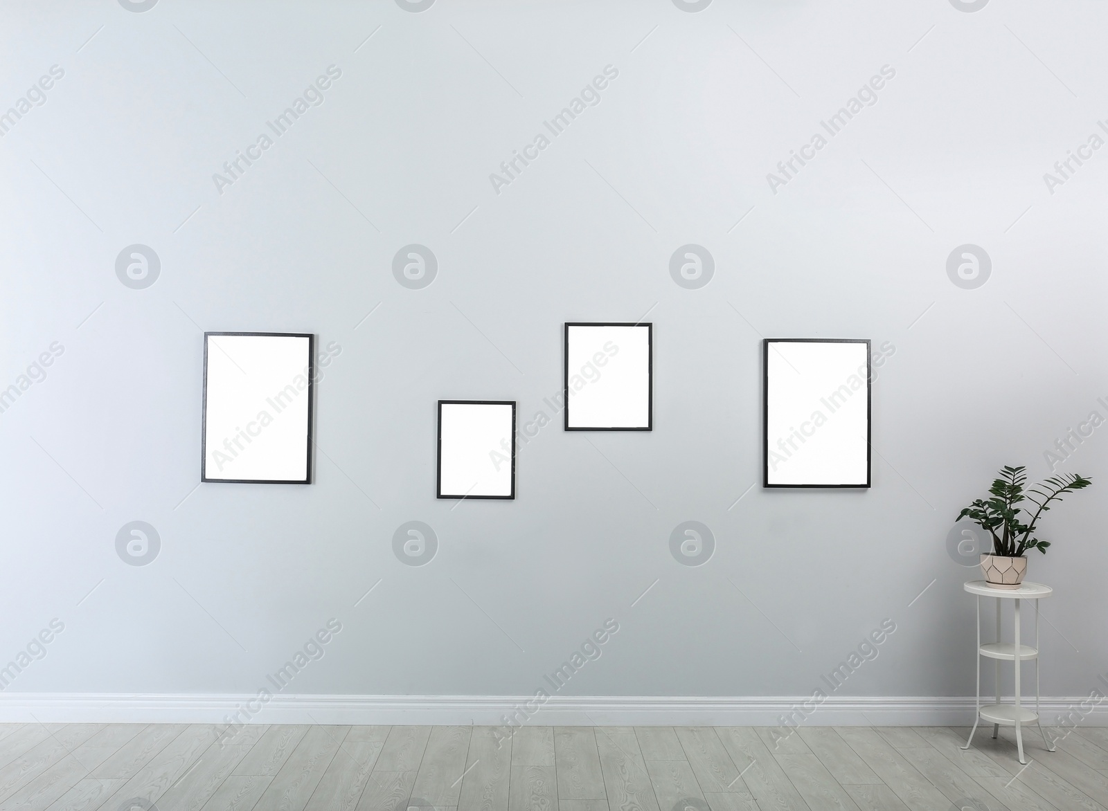 Photo of Frames with empty canvases on wall in modern art gallery. Mockup for design