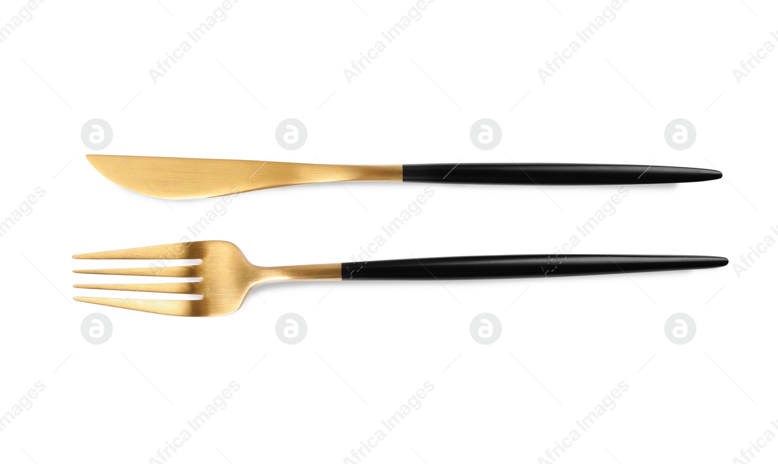 Photo of New golden fork and knife with black handles on white background, top view