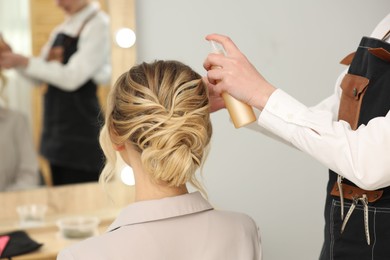 Photo of Hair styling. Professional hairdresser working with client indoors, closeup