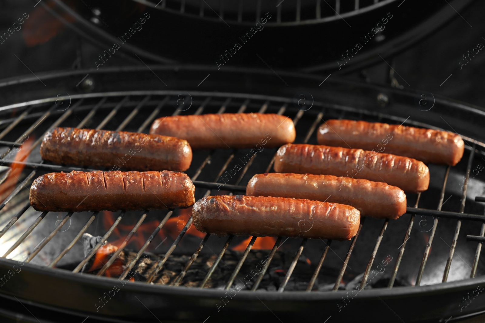 Photo of New modern barbecue grill with tasty sausages, closeup