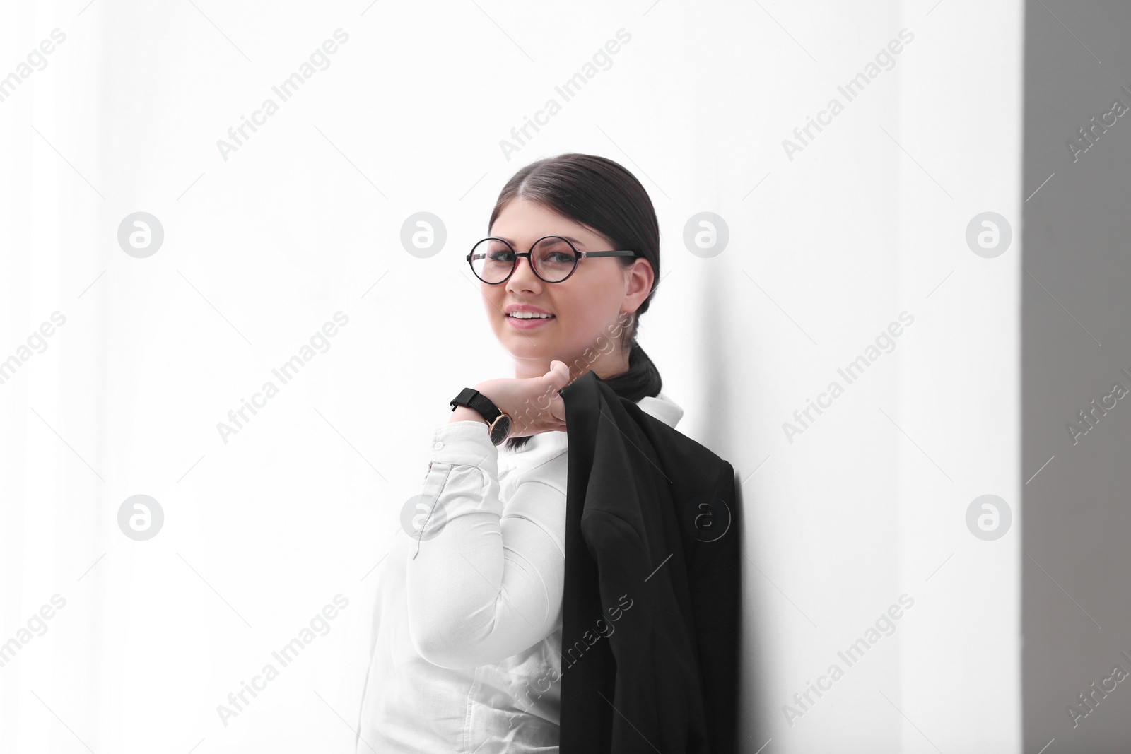Photo of Beautiful overweight businesswoman posing on light background. Plus size model