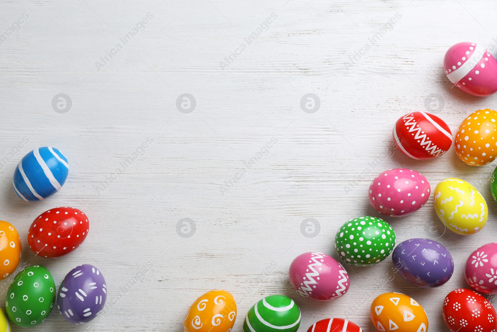 Photo of Decorated Easter eggs and space for text on wooden background, top view