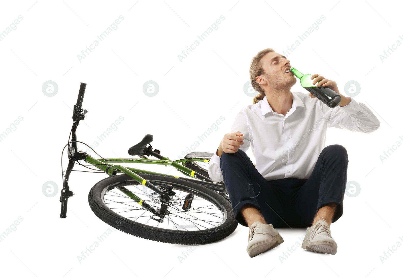 Photo of Depressed young man with bottle of wine near bicycle on white background