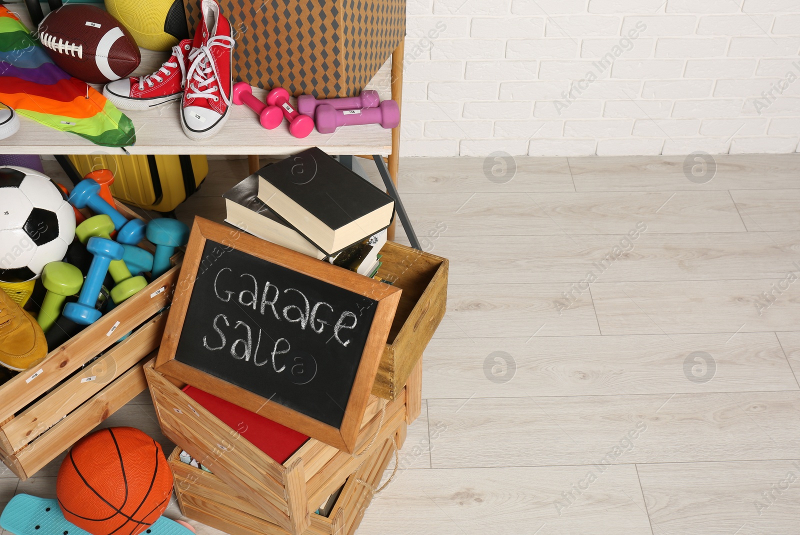 Photo of Sign Garage Sale written on blackboard near many different stuff indoors, above view. Space for text