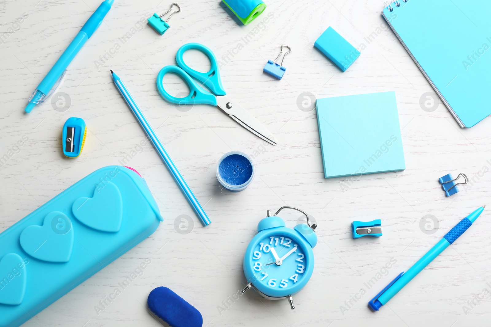 Photo of Different bright school stationery on white wooden background, flat lay