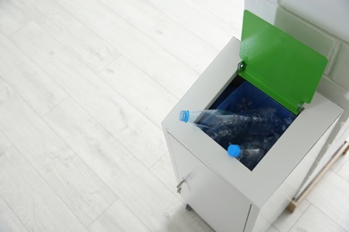 Photo of Metal bin with garbage indoors, space for text. Waste recycling