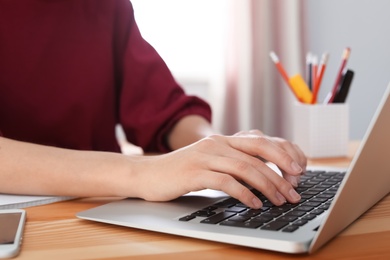 Young woman working with laptop at desk. Home office