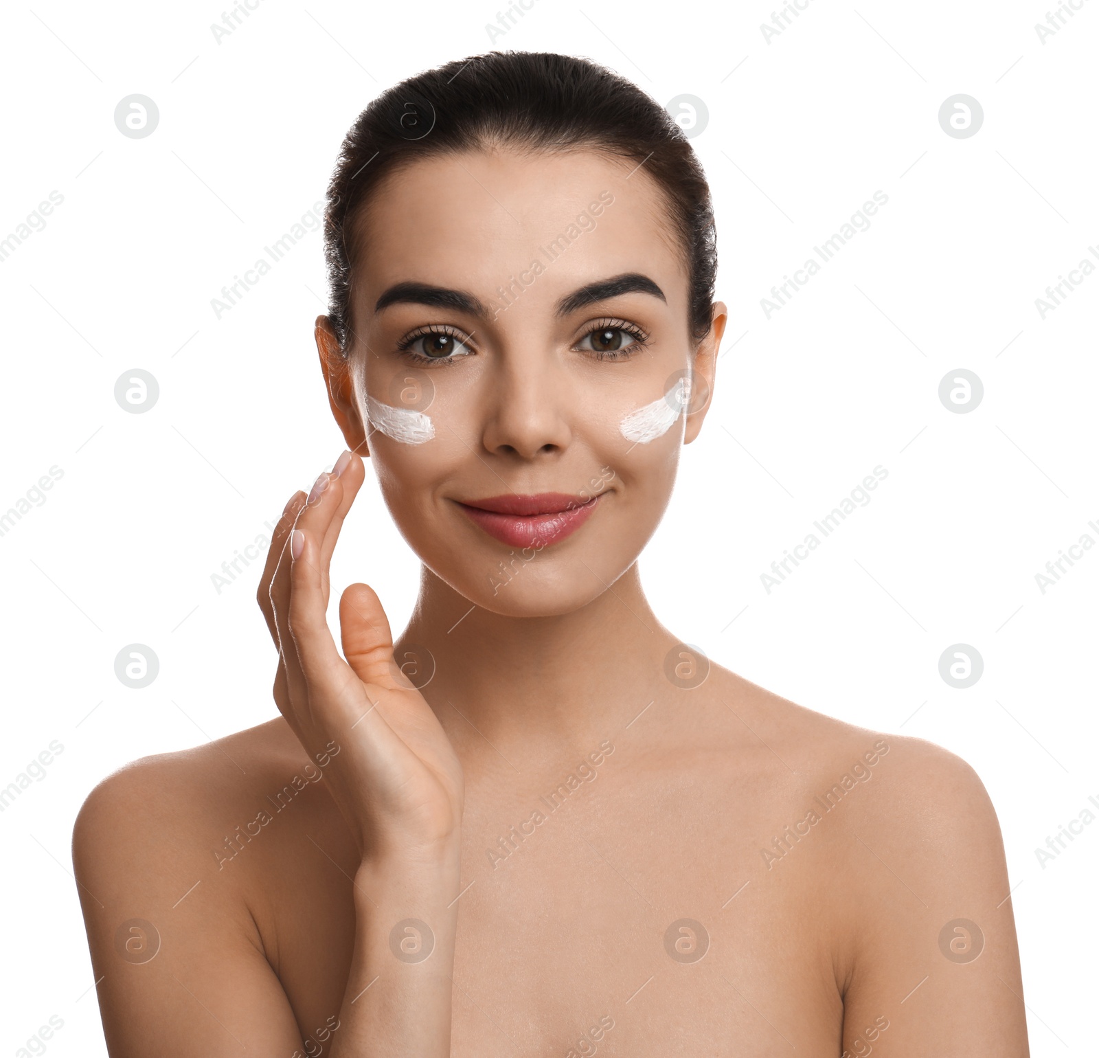 Photo of Young woman applying facial cream on white background