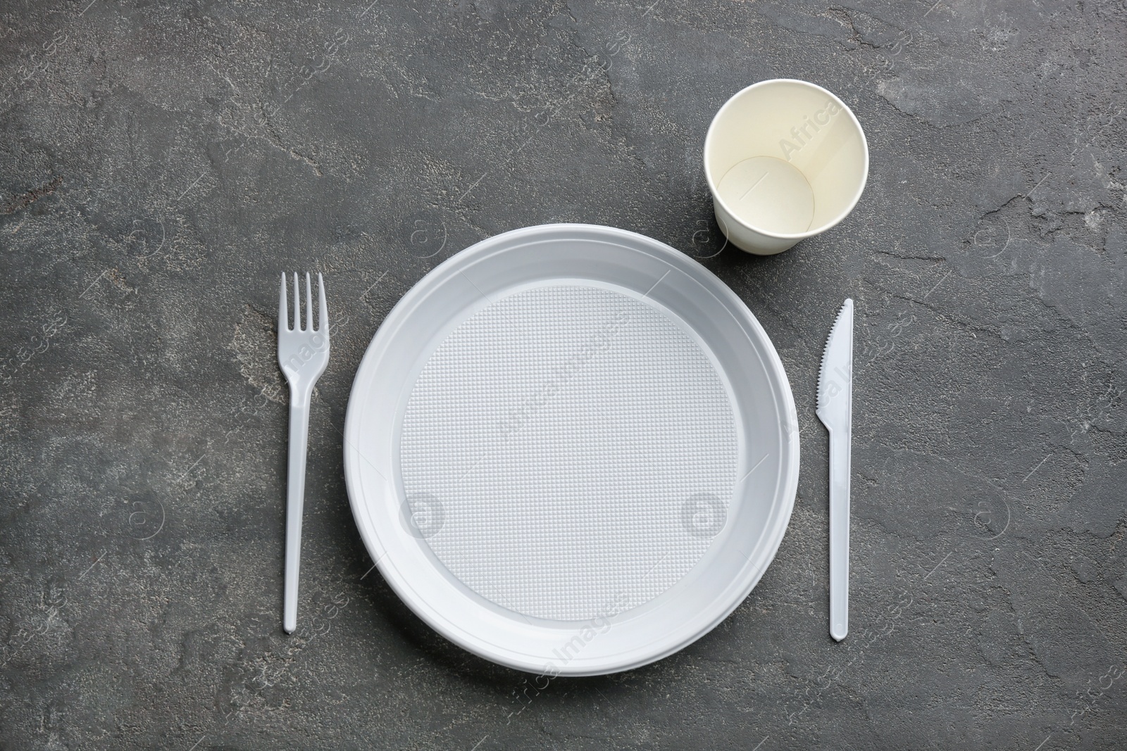 Photo of Composition with plastic dishware on grey background, flat lay. Picnic table setting