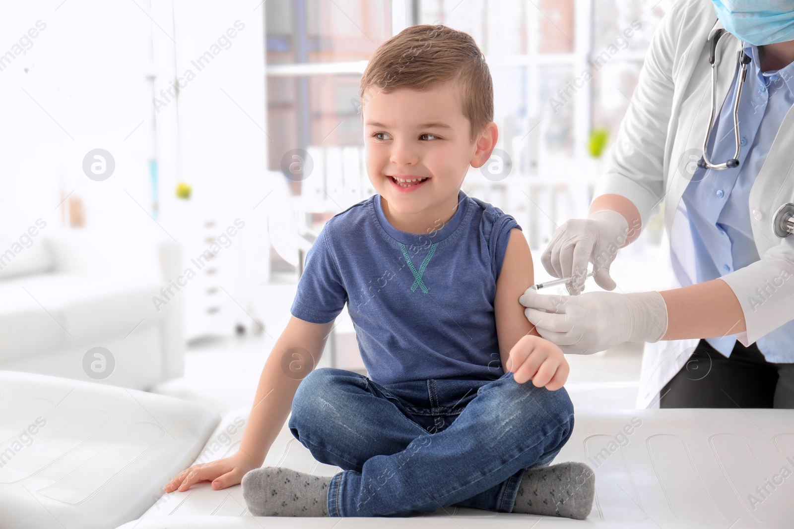 Photo of Doctor vaccinating little boy in hospital