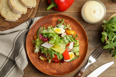 Photo of Delicious salad with lettuce served on wooden table, flat lay