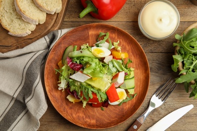 Delicious salad with lettuce served on wooden table, flat lay