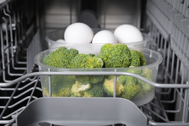 Cooking raw broccoli and eggs in modern dishwasher, closeup