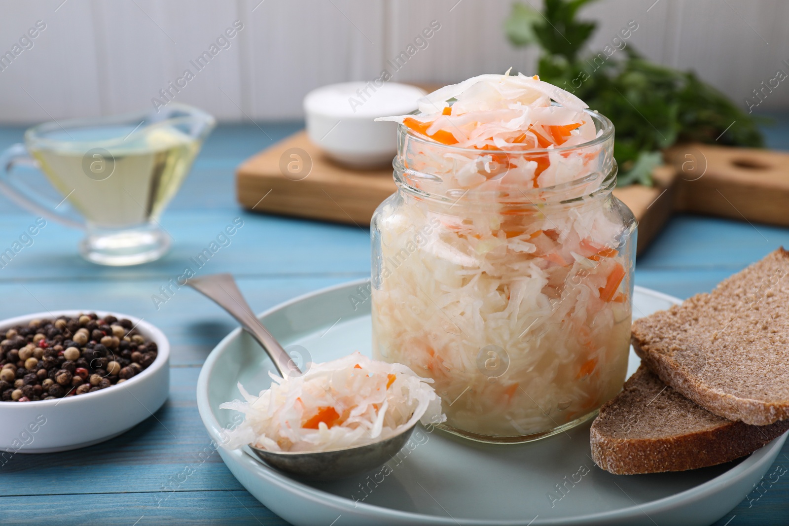 Photo of Tasty sauerkraut on light blue wooden table