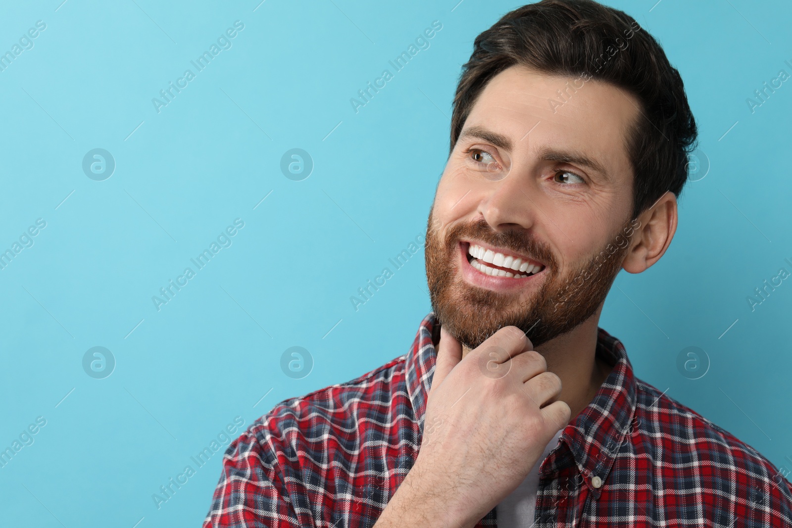 Photo of Portrait of smiling man with healthy clean teeth on light blue background. Space for text