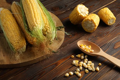 Tasty sweet corn cobs on wooden table