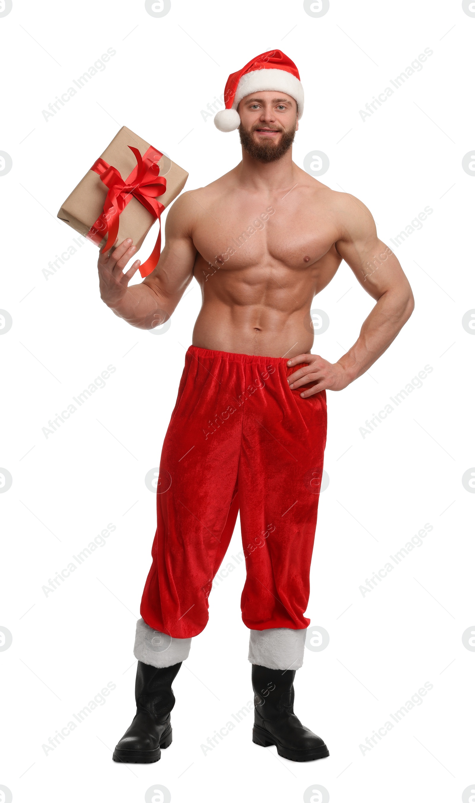Photo of Attractive young man with muscular body in Santa hat holding Christmas gift box on white background