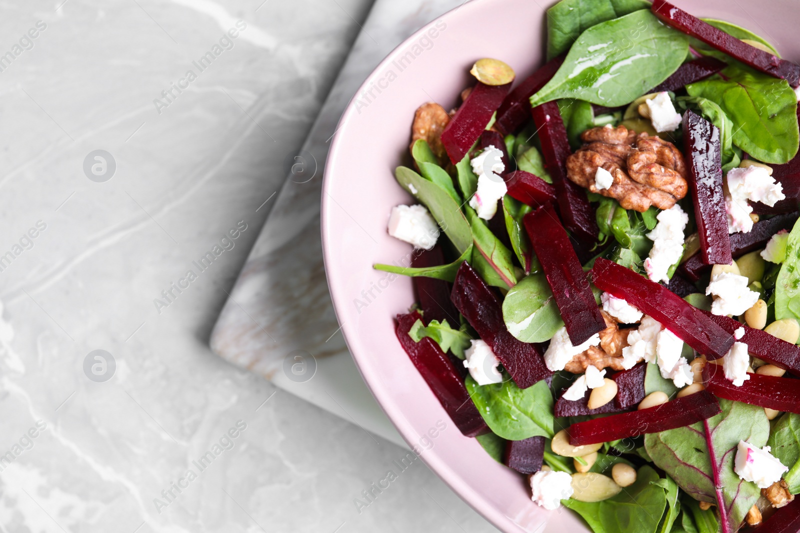 Photo of Delicious beet salad served on grey marble table, top view. Space for text