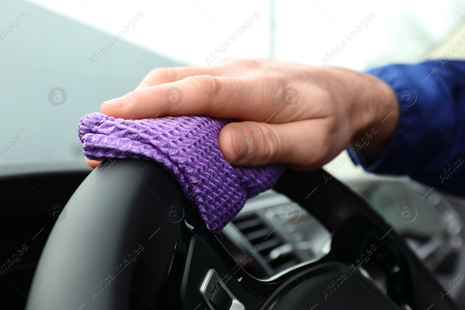 Photo of Car wash worker cleaning automobile interior, closeup